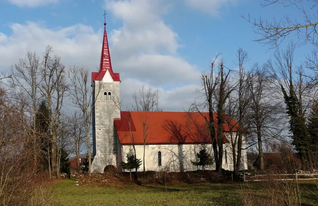 Cerkev svetega Lovrenca v Dolenji vasi pri Cerknici, stoji na samem na travniku, okoli nje so drevesa brez listja.